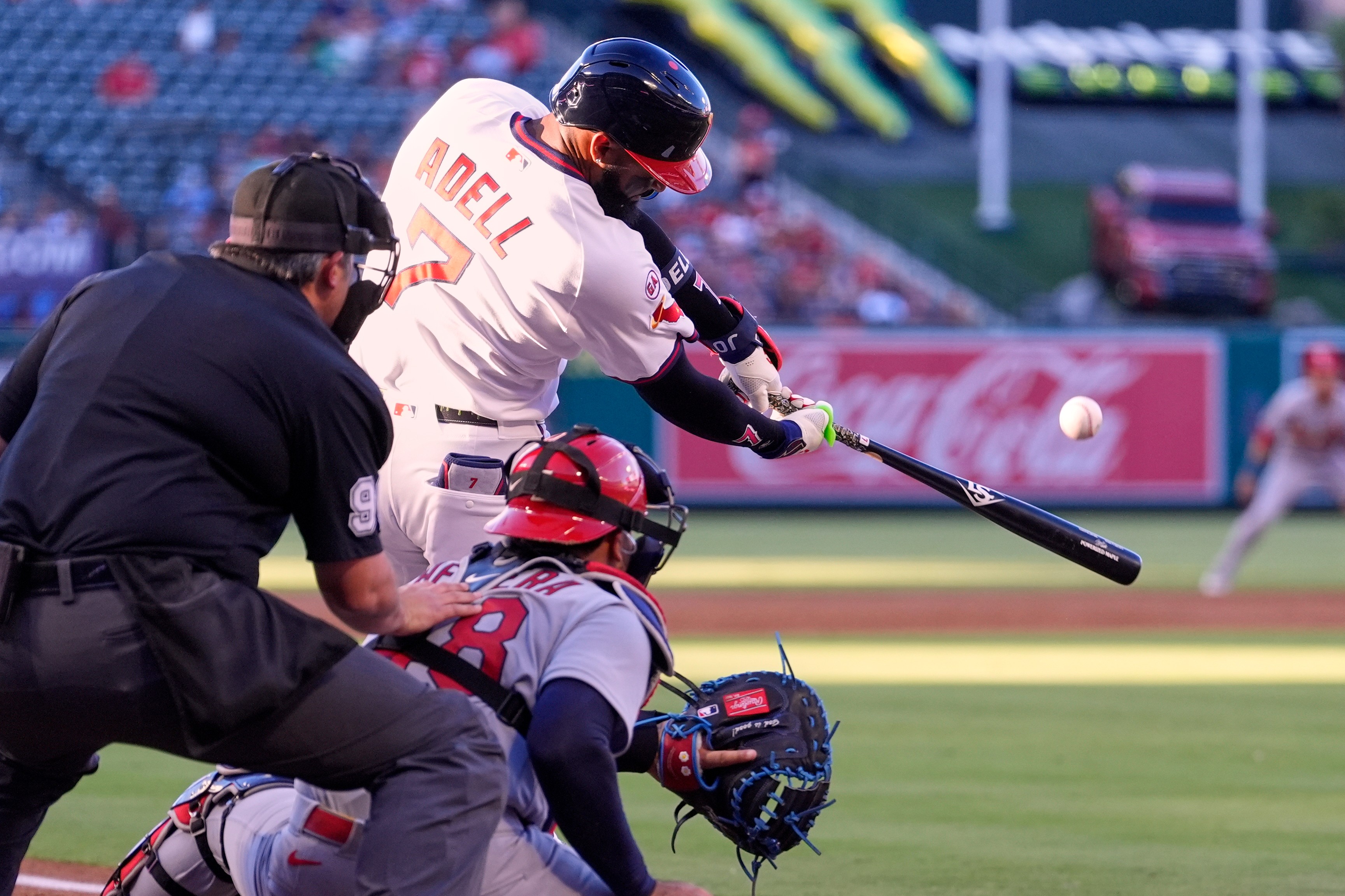 Los Angeles Angels' Jo Adell, center, hits a two-run home run as St. Louis Cardinals catcher Iván Herrera, right, and home plate umpire Mark Ripperger watch during the first inning of a baseball game Tuesday, July 21, 2026, in Anaheim, Calif. (AP Photo/Mark J. Terrill)