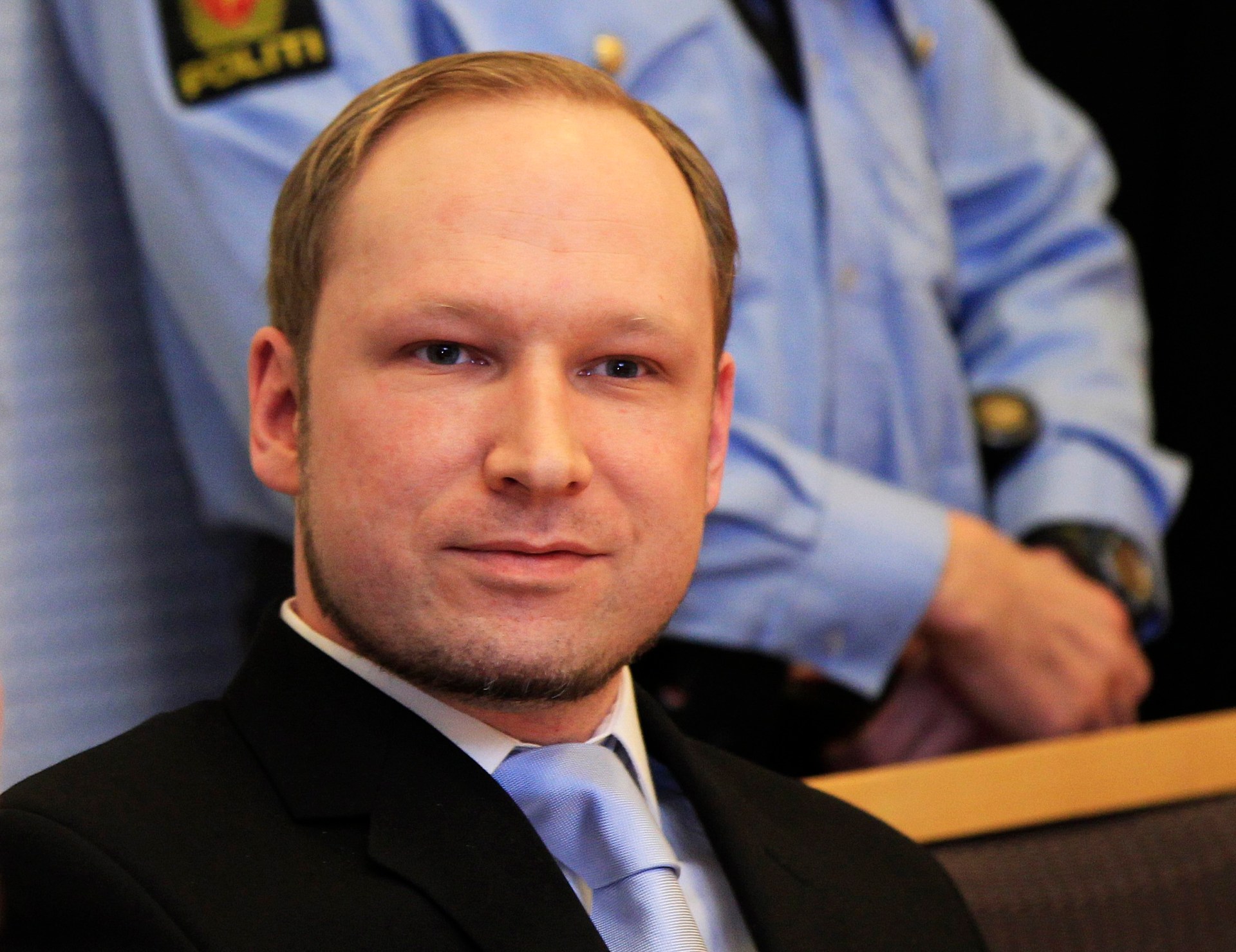 Norwegian Anders Behring Breivik, who killed 77 people, as he arrives at a court hearing in Oslo, Norway. He has short light hair and short facial hair.