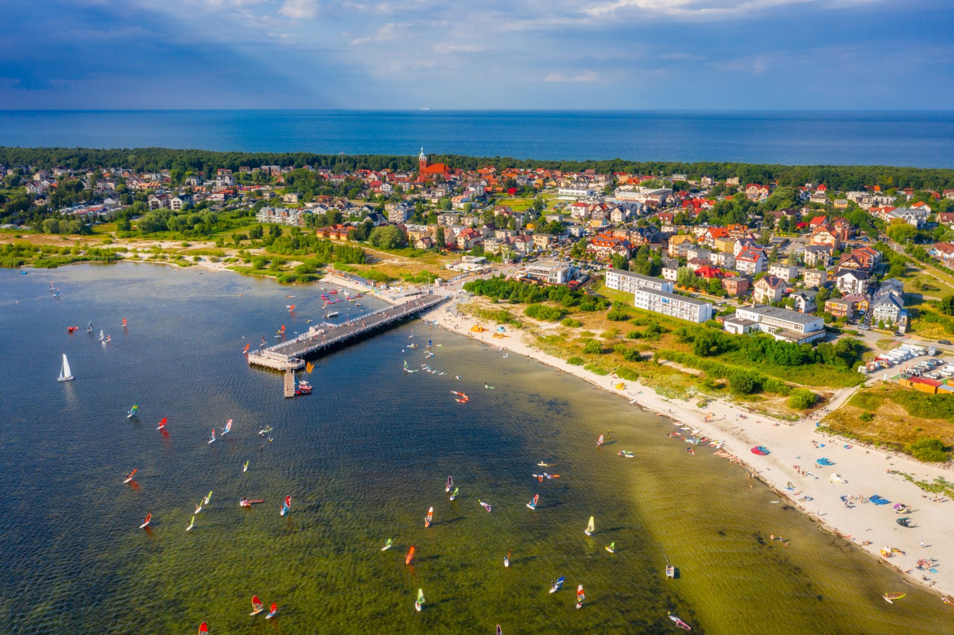 An aerial view over the water, sandy beach and pier of Puck Bay in Jastarnia, Poland.
