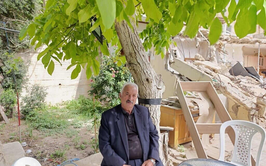Fakhri Abu Diab sits beside his demolished home in the al-Bustan neighborhood of East Jerusalem, May 20, 2026 (Zev Stub/Times of Israel)