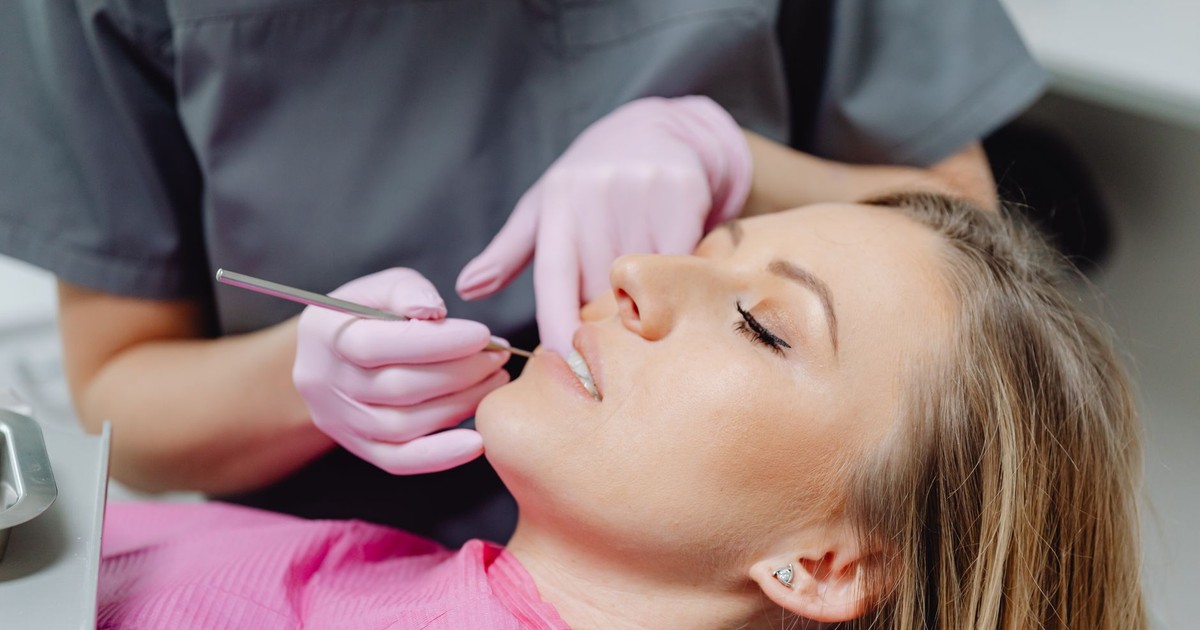 A female patient receives a dental examination by a dentist in a clinic.
