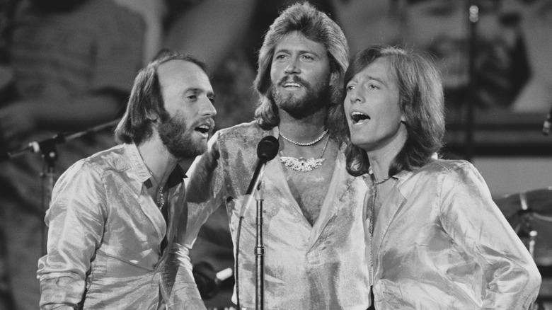 Bee Gees singing on stage in shiny costume