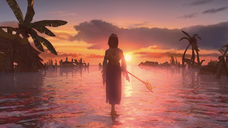 Yuna watches the sunset while standing in water in Final Fantasy X