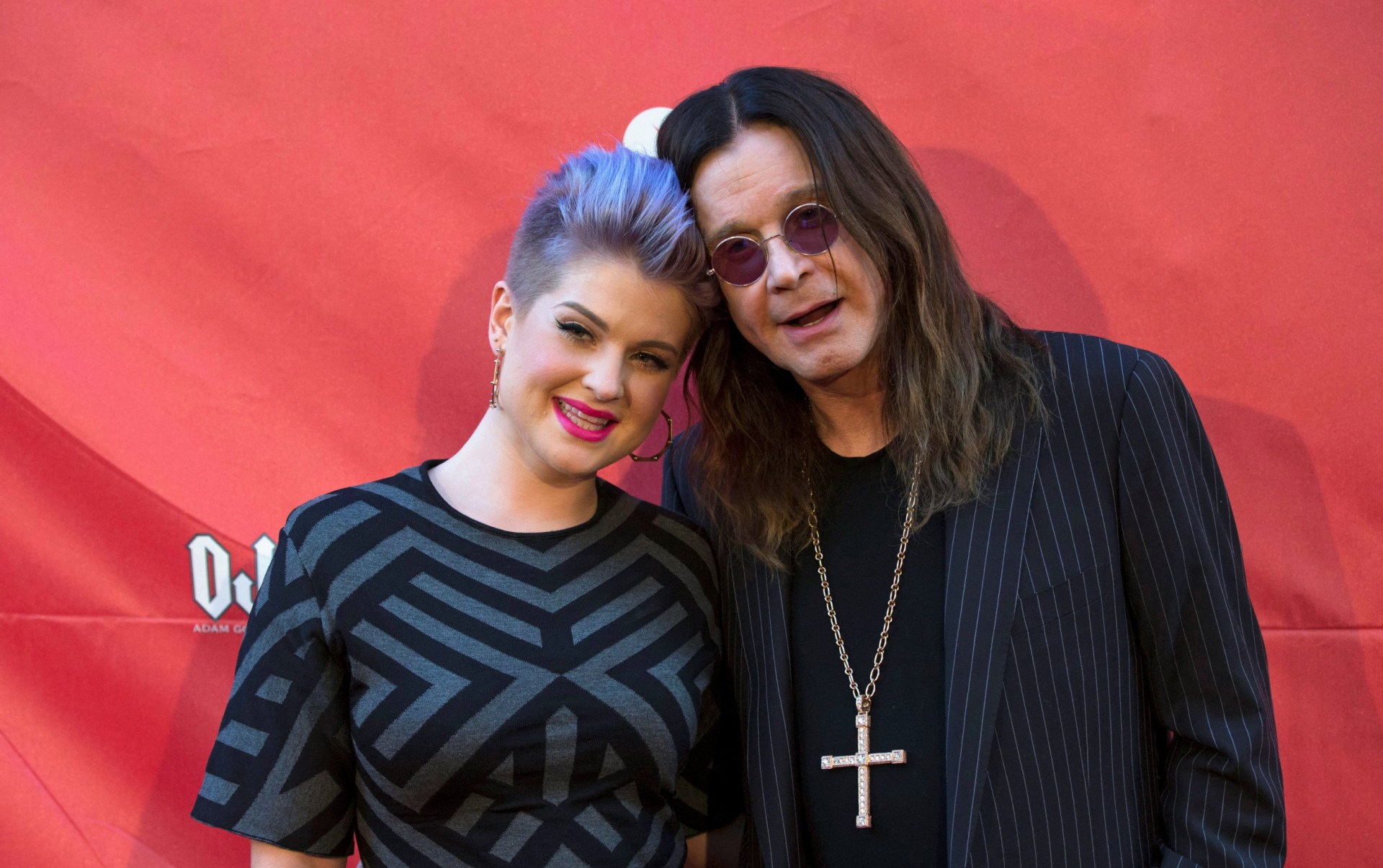 Musician Ozzy Osbourne (R) and his daughter Kelly Osbourne pose with their heads together at the 10th Annual MusiCares MAP Fund Benefit concert in 2014