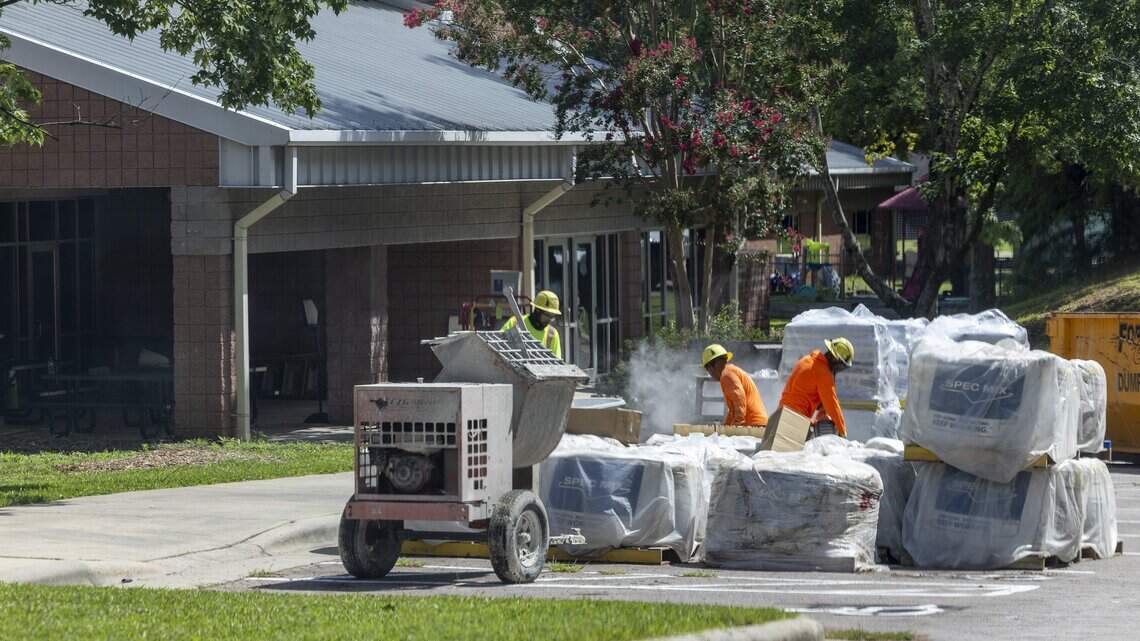 Masonry workers perform repairs outside Durant Road Elementary School in Raleigh on Tuesday, July 21, 2026. Repairs will not be complete before classes start July 30, forcing a temporary relocation to Abbotts Creek Elementary School.