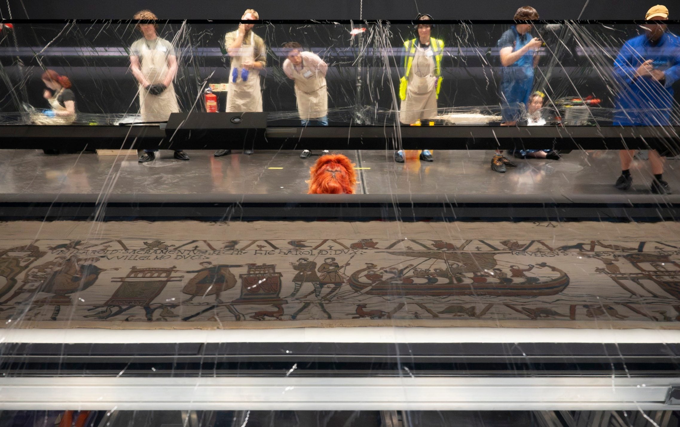 Staff prepare for the move behind the long, wheeled table in a hangar-like gallery