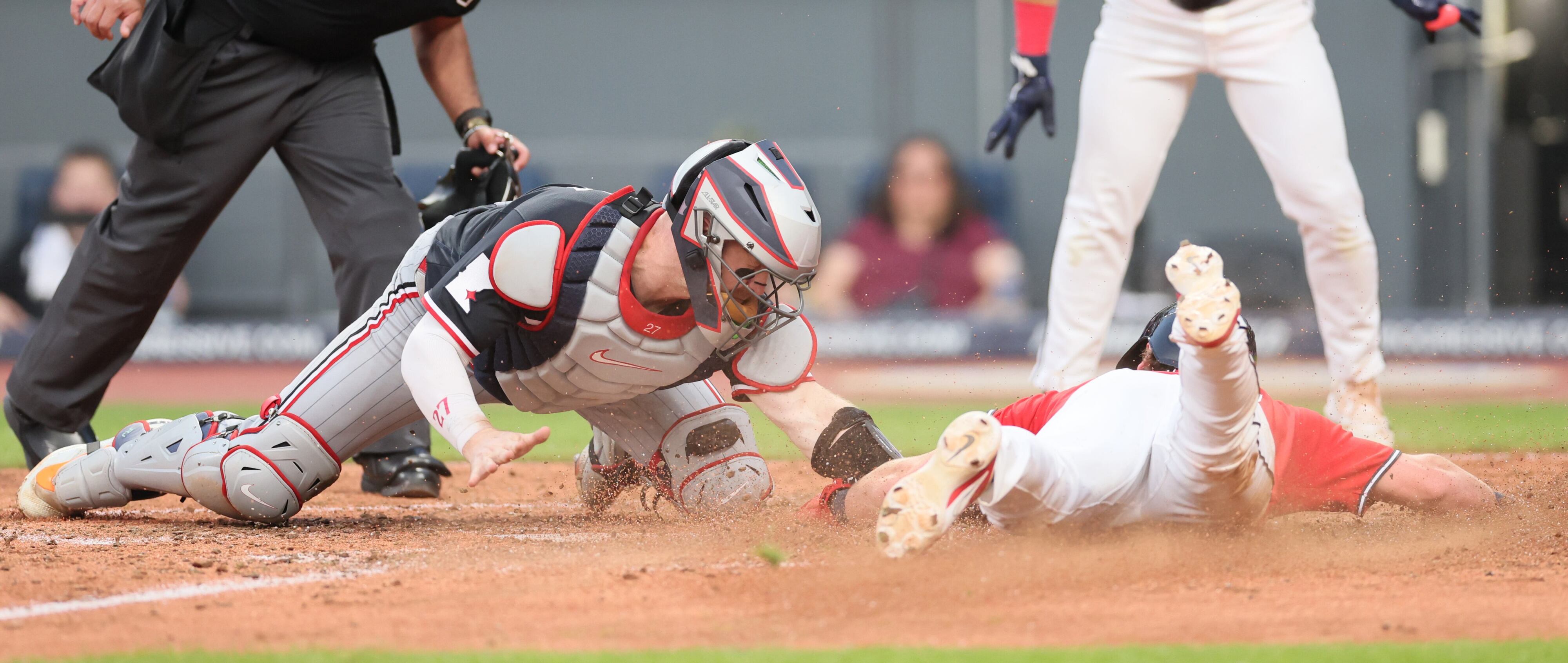 Cleveland Guardians second baseman Travis Bazzana slides to home plate as Minnesota Twins catcher Ryan Jeffers applies the tag in the sixth inning. After review, Bazzana was called safe at home.