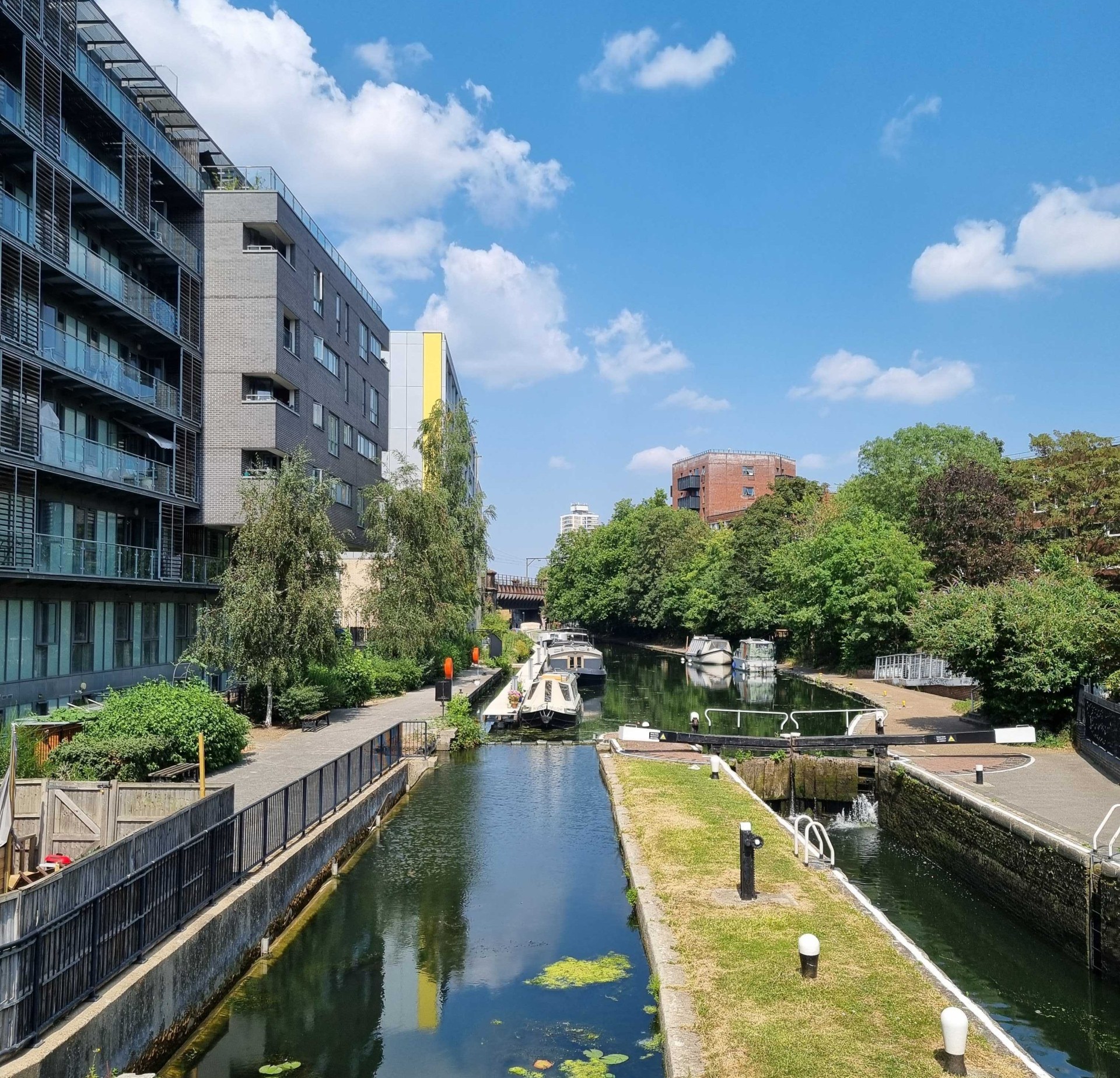 A canal in London with apartments beside it on a bright sunny day