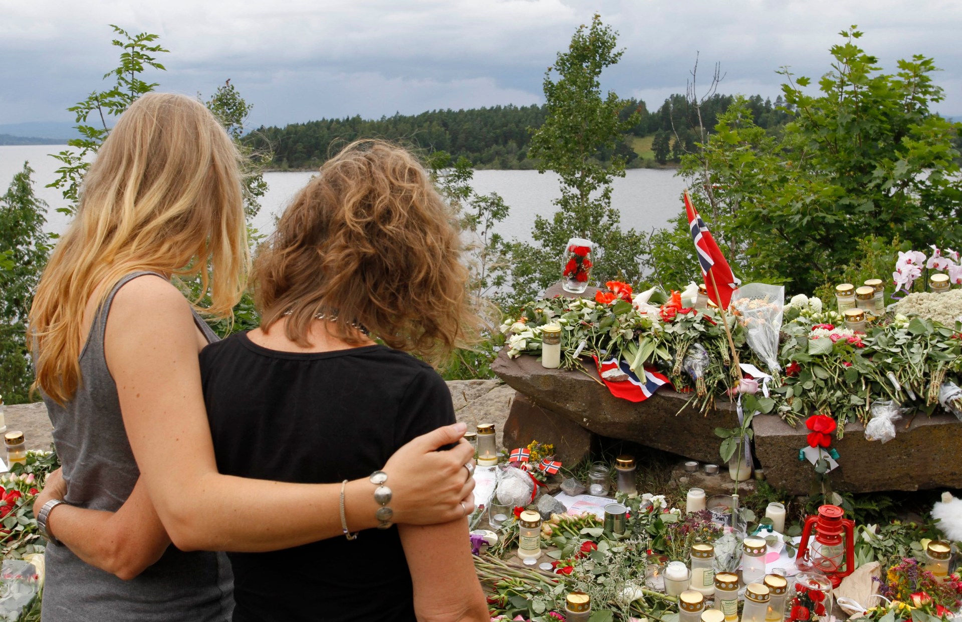 Two young women stand in silence after placing flower near Sundvollen close to the Utoya island, near Oslo.