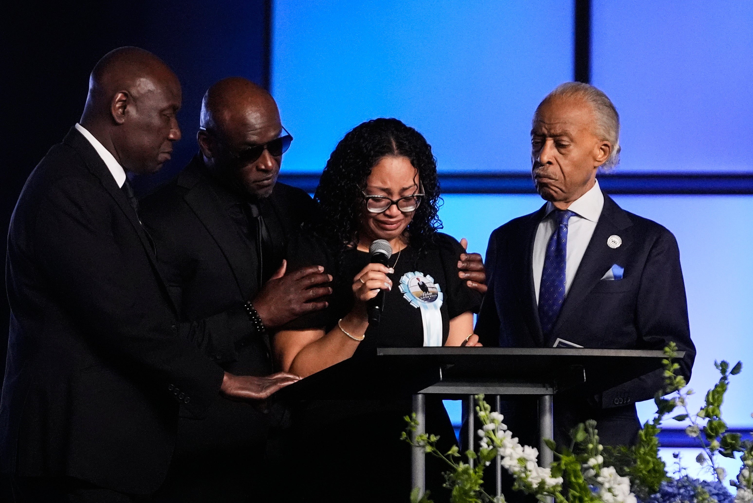 Christine Wonsley is flanked by her husband Elmore, attorney Ben Crump and Rev, Al Sharpton during the service (AP)