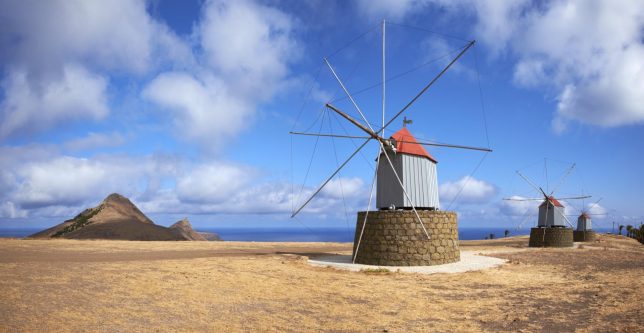 The sun shines down on three traditional windmills on the Portuguese island of Porto Santo.