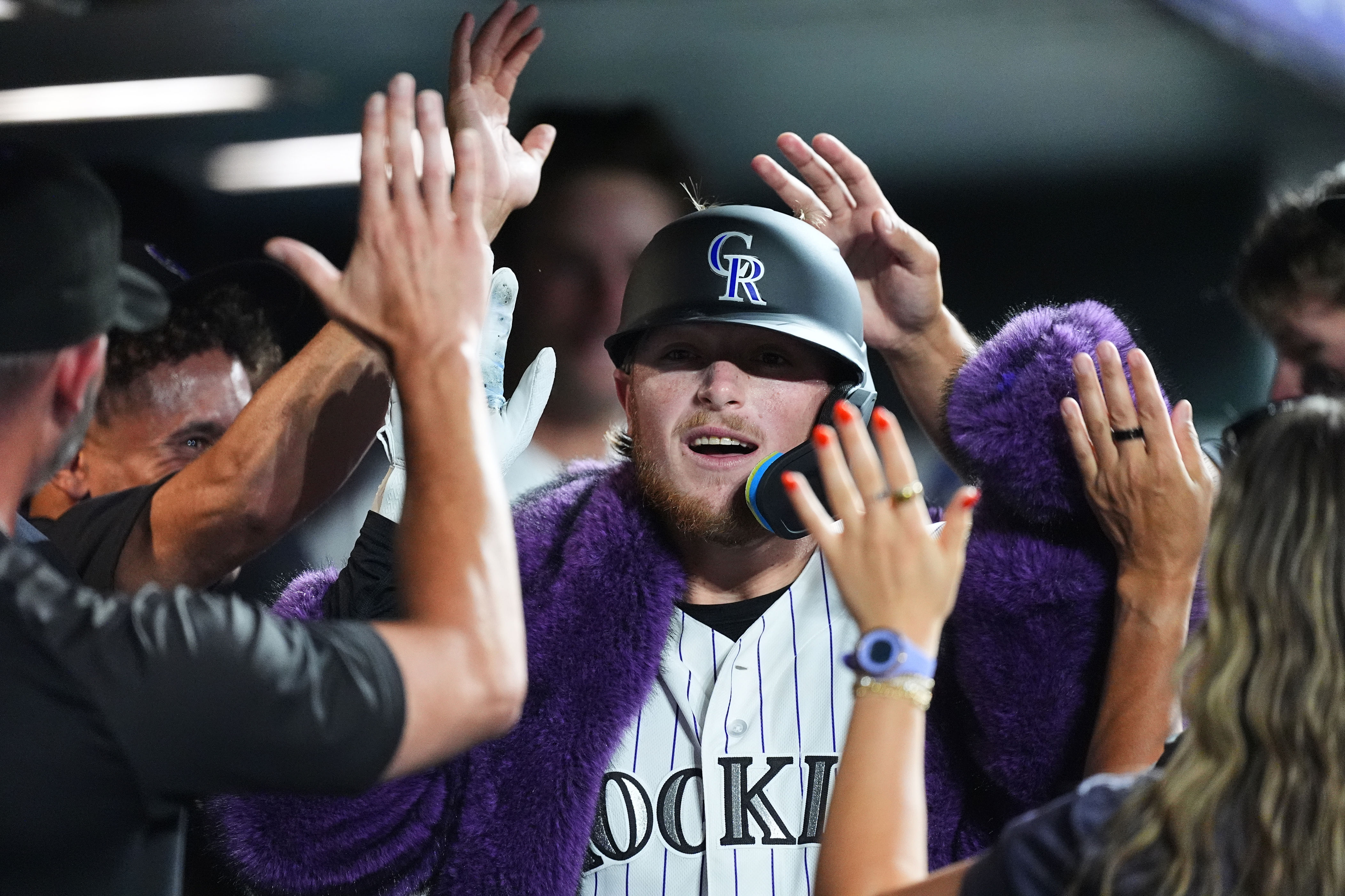 Colorado Rockies' Hunter Goodman is congratulated as he returns to the dugout after hitting a solo home run off Washington Nationals relief pitcher Clayton Beeter in the eighth inning of a baseball game Tuesday, July 21, 2026, in Denver. (AP Photo/David Zalubowski)