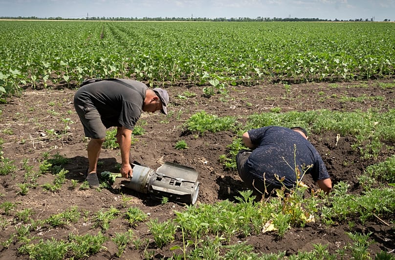 FILE. Farmers inspect a Russian rocket fragment after shelling on a sunflower field in the Donetsk region, Ukraine, 21 June 2022