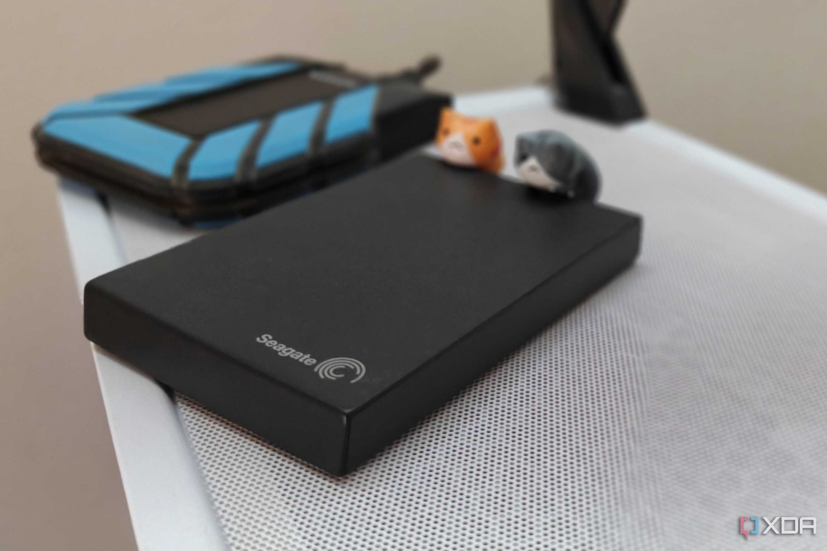 Two external hard drives lying on a white gaming PC