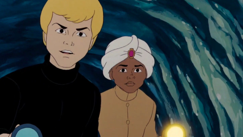 Johnny Quest and his pal Hadji hold flashlights in a cave in The New Adventures of Johnny Quest