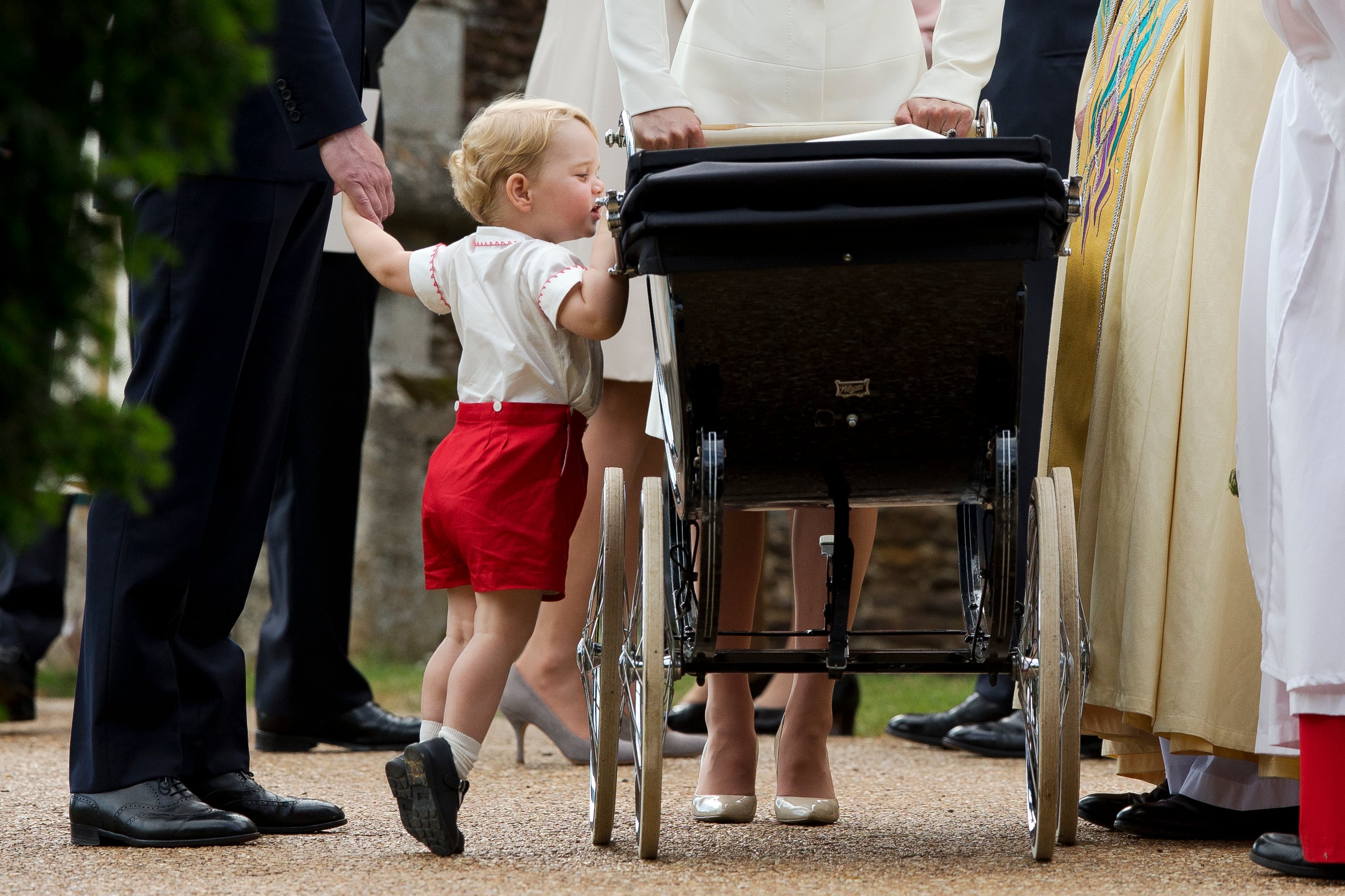 2015: Catherine, Duchess of Cambridge, and Prince William, Duke of Cambridge stand as Prince George of Cambridge looks into Princess Charlotte of Cambridge's pram as they leave the Church of St Mary Magdalene on the Sandringham Estate after the Christening of Princess Charlotte of Cambridge on July 5, 2015, in King's Lynn, England.