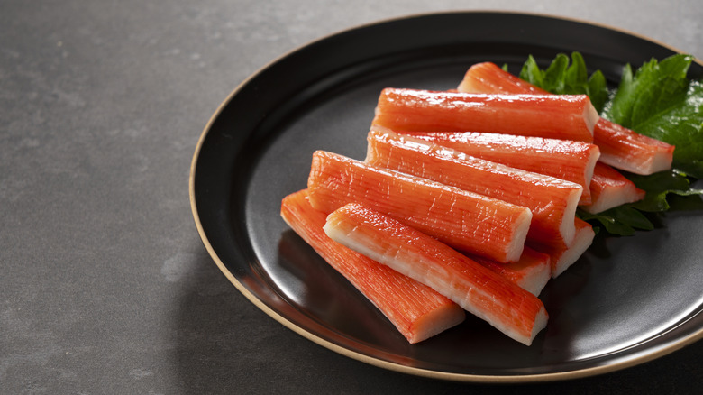 Crab sticks arranged on black plate