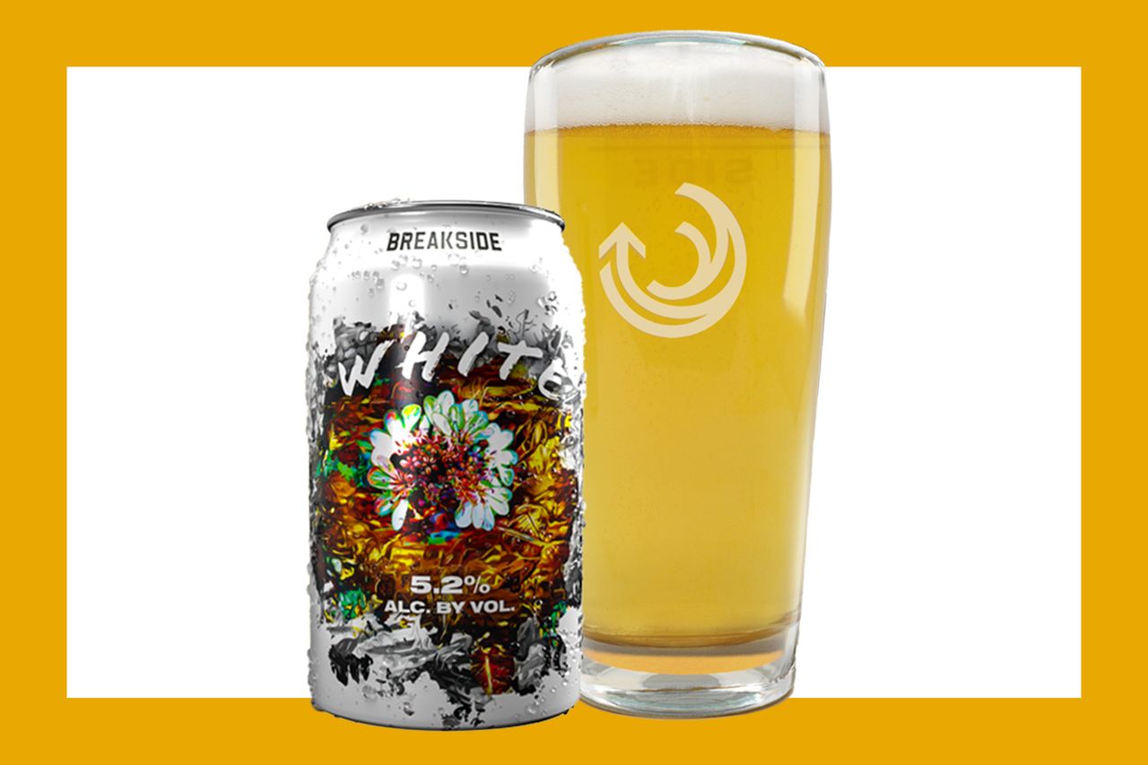 A can of Breakside White beer next to a glass filled with a beverage styled against a yellow background