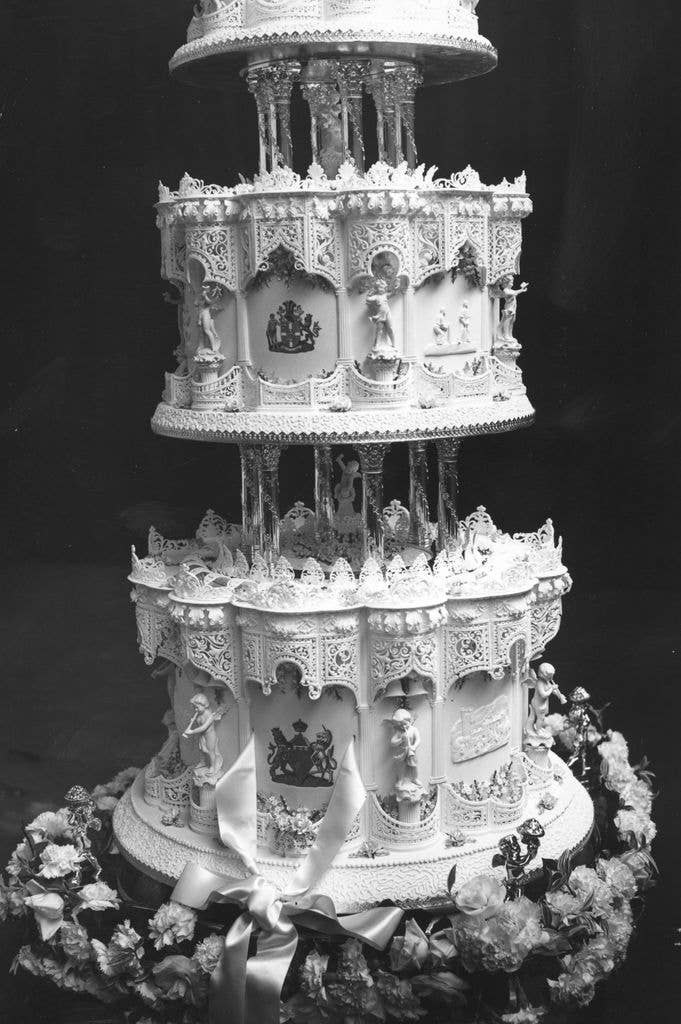 : The official wedding cake for HRH Princess Elizabeth's wedding. It is intricately decorated with armorial bearings of the Princess and Lieutenant Mountbatten and depicts scenes from their lives on the bottom two tiers
