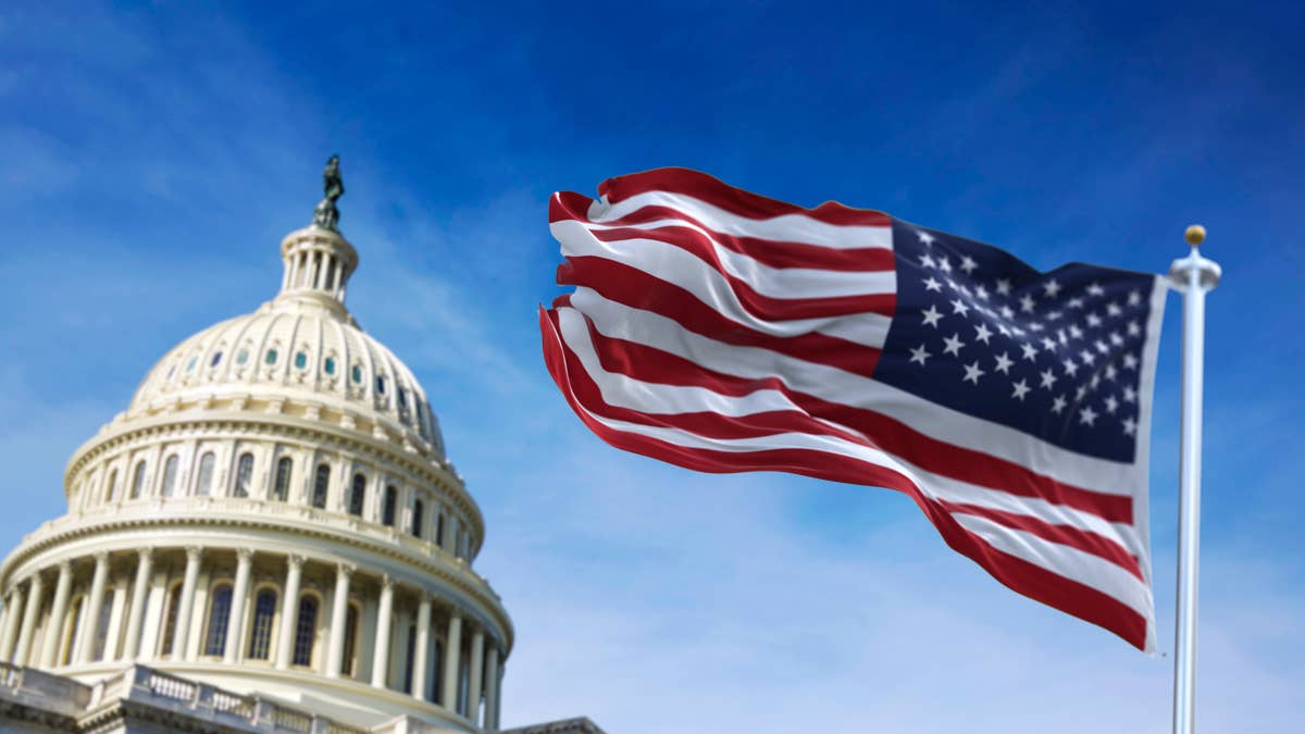 americanflagwavingwiththeuscapitolhillinthe