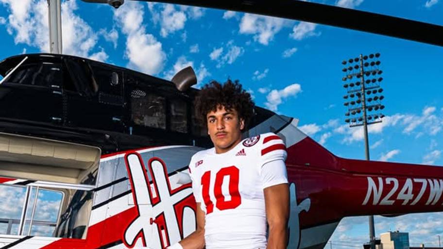 Brennan Drummond poses beside a Nebraska football helicopter