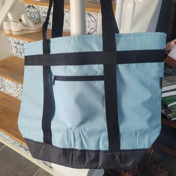 A large tote bag with a front zipper pocket and sturdy straps
