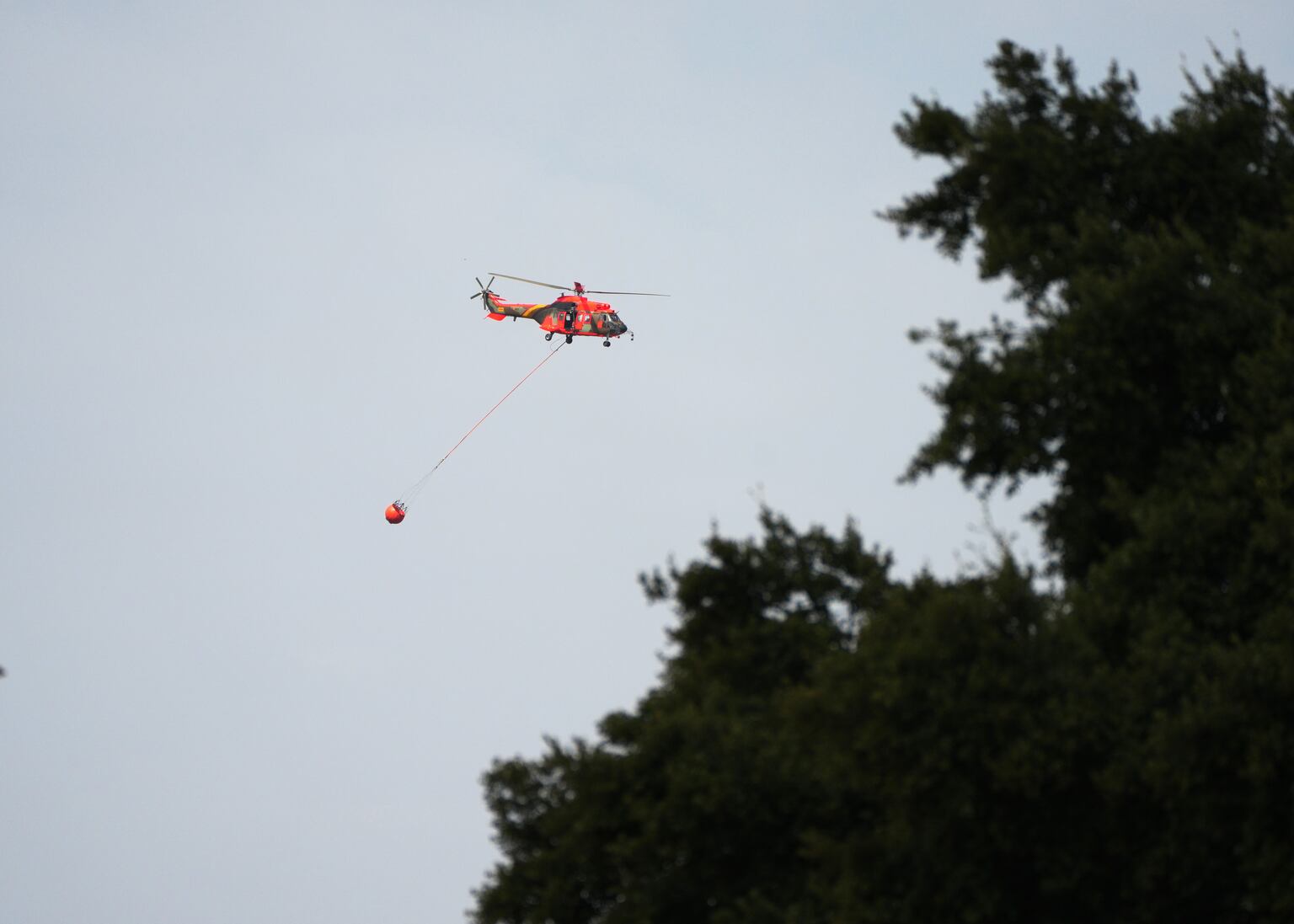 A firefighting helicopter carries water to battle a wildfire in Guadalajara (Manu Fernandez/AP)