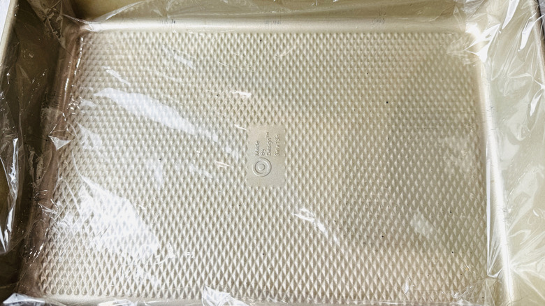 Baking pan lined with plastic wrap