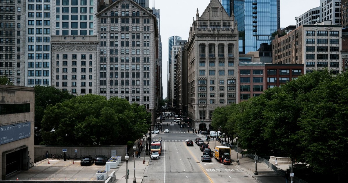 Cityscape view of a Chicago street with historic and modern buildings on a clear day.