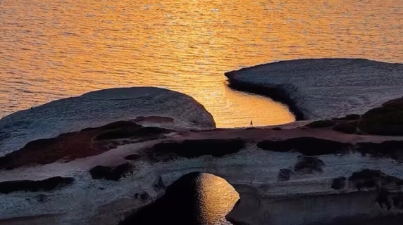 Il tramonto infiamma S'Archittu: lo spettacolo sull'arco di mare della ...