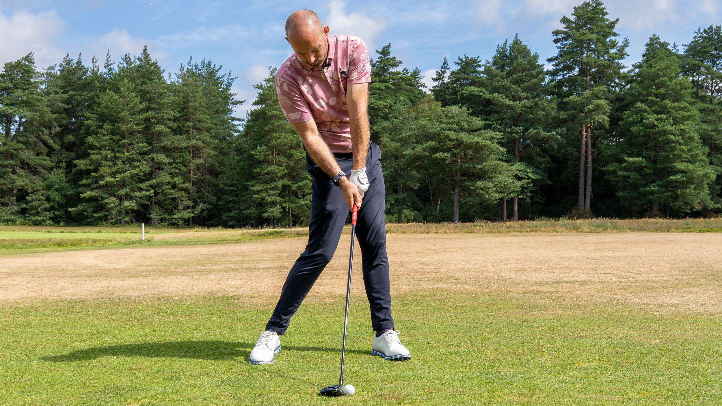 A golfer hitting a fairway wood