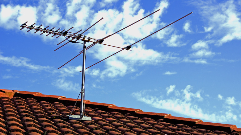 TV antenna on a rooftop against a blue sky