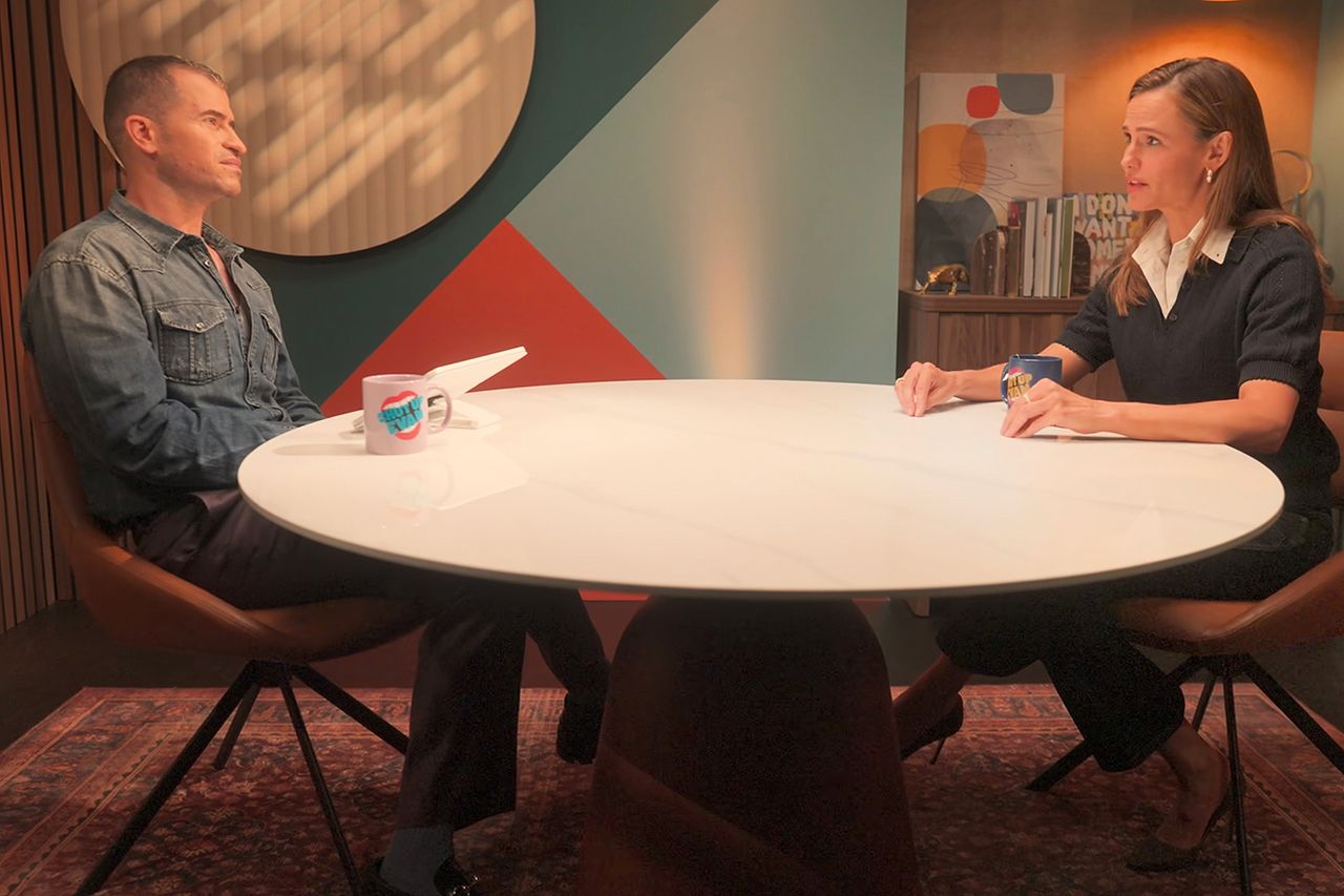 Jennifer Garner seated at a table during a podcast interview