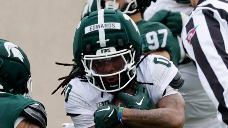 Michigan State running back Cam Edwards (0) tries to avoid defensive back Michael Richard (7)