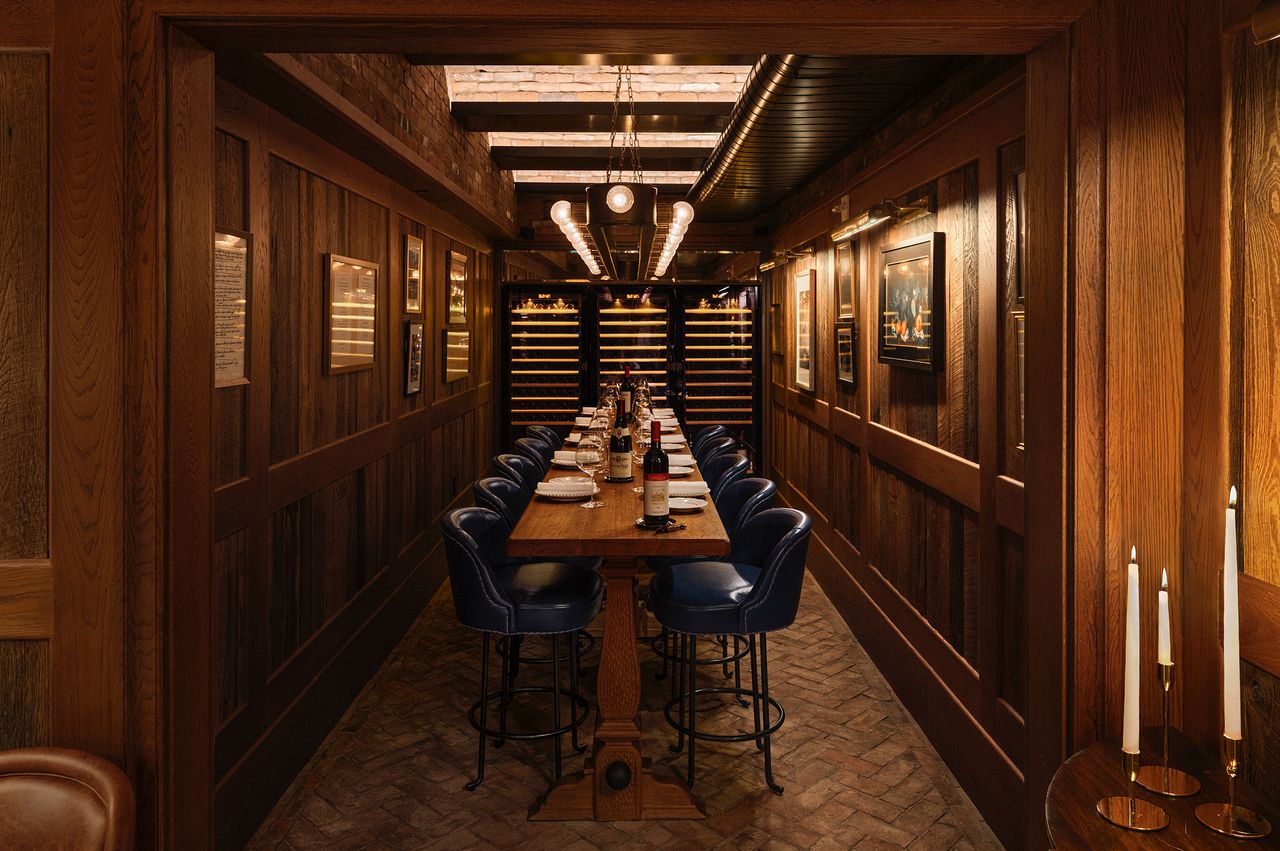 A dining area with a long table and chairs positioned in an elegant room