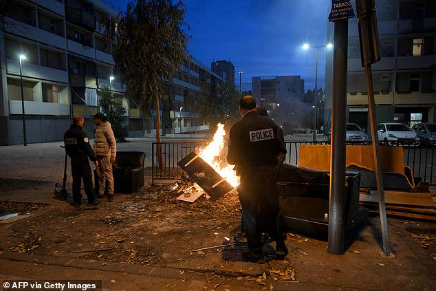 Police officers check the IDs of young lookouts at the entrance of La Busserine housing project in the northern districts of Marseille