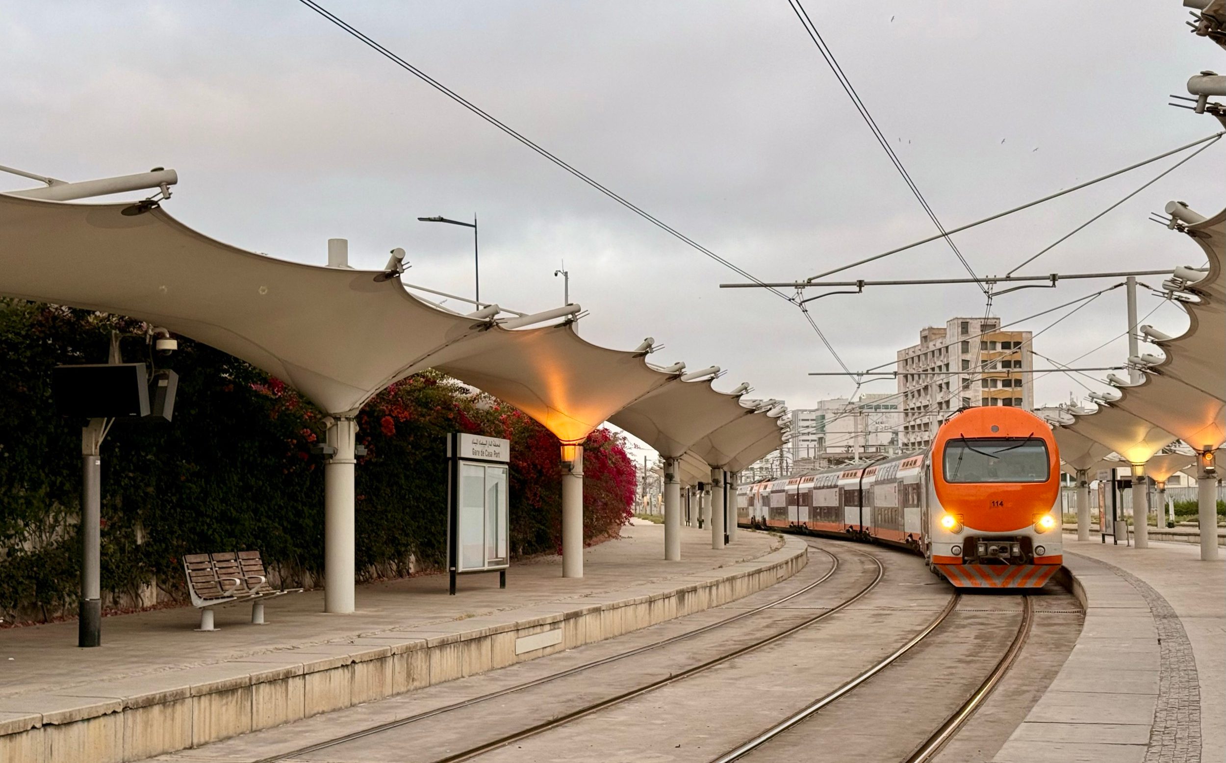 A double-decker train pulls into a platform in Casa Port station