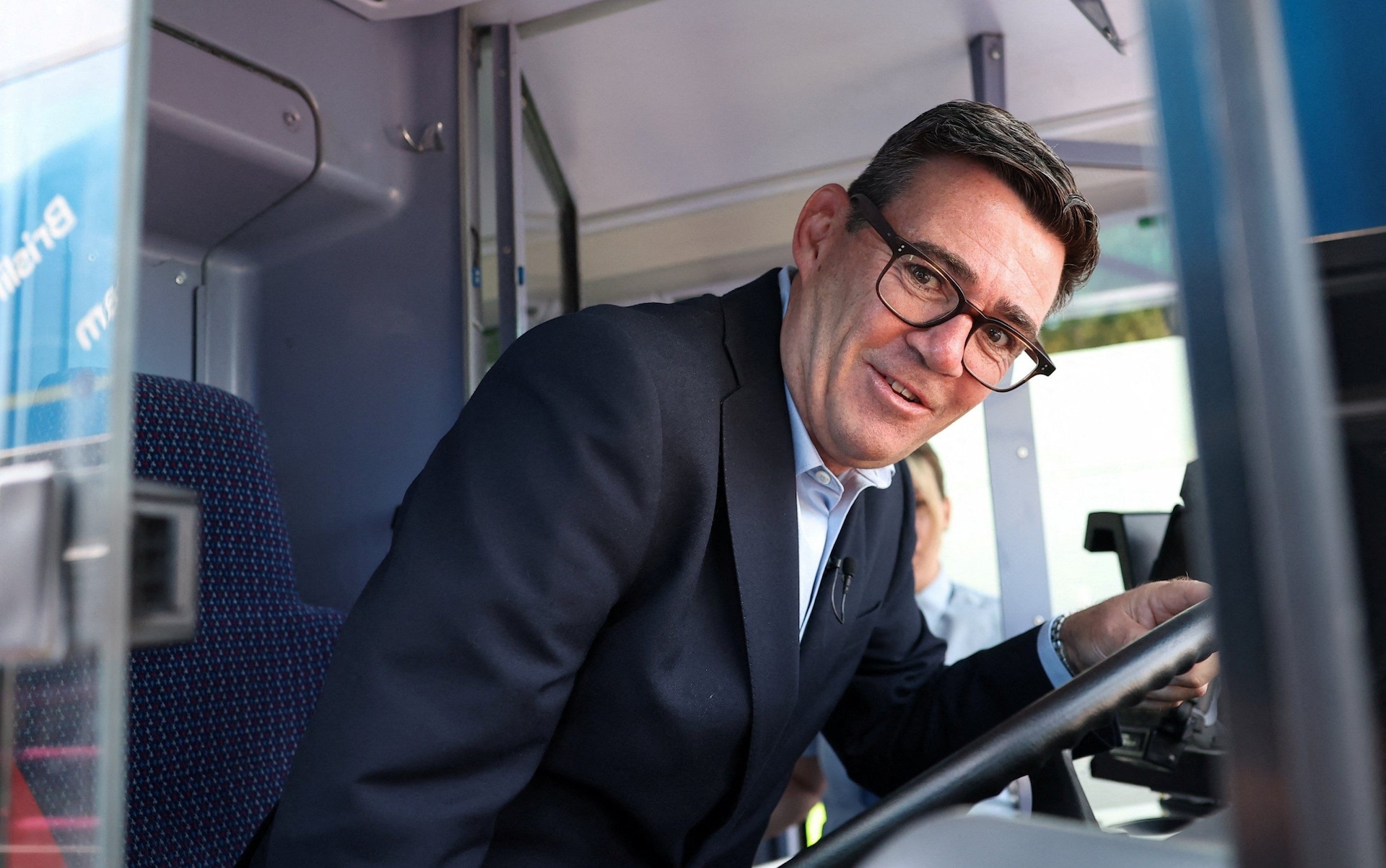 Andy Burnham in the driver's seat of a bus