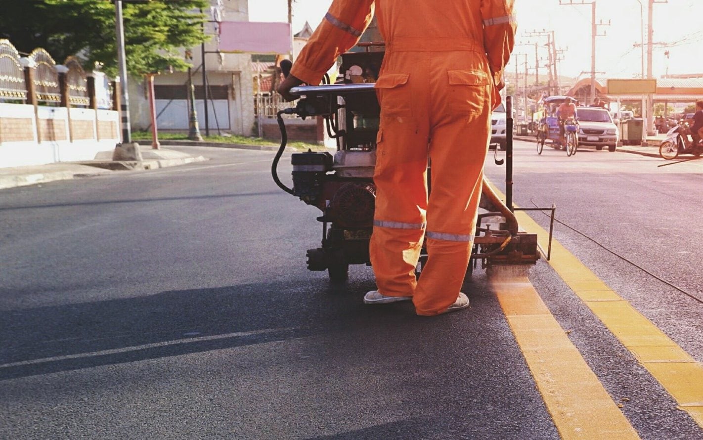 Road workers marking yellow lines on the road
