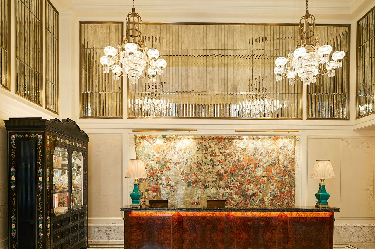 Lobby reception desk with decorative wall and hanging chandeliers