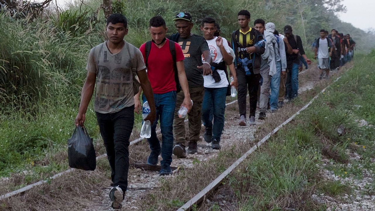 Migrants walk on train tracks on their journey from Central America to the U.S. border., in Palenque, Chiapas state, Mexico, Wednesday, Feb. 10, 2021.