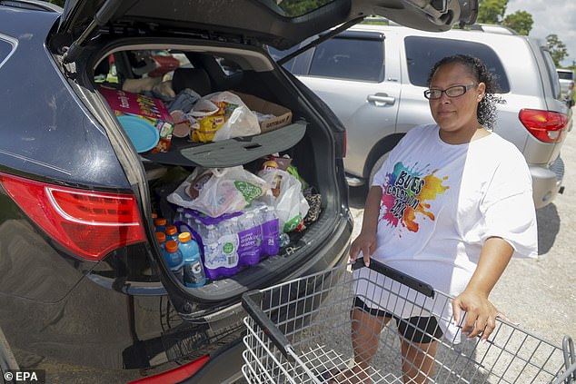 A Louisiana resident stands by her car after securing supplies ahead of Tropical Storm Bertha's landfall on July 22