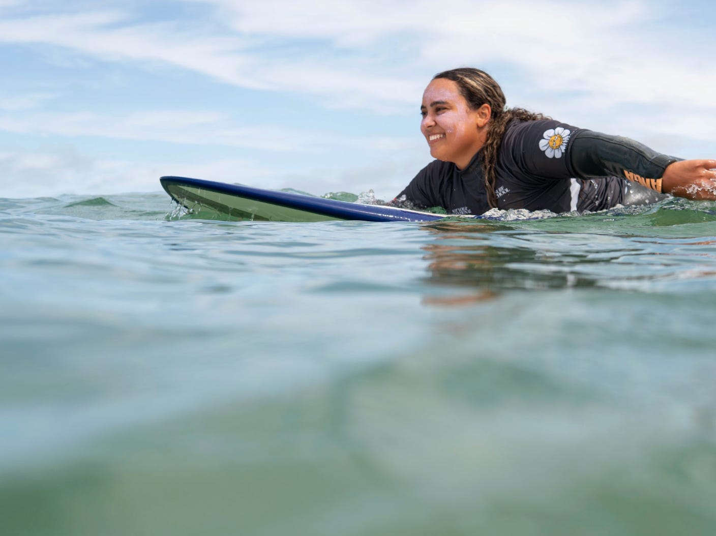 The writer surfing in Portugal, with sunscreen with on her face.