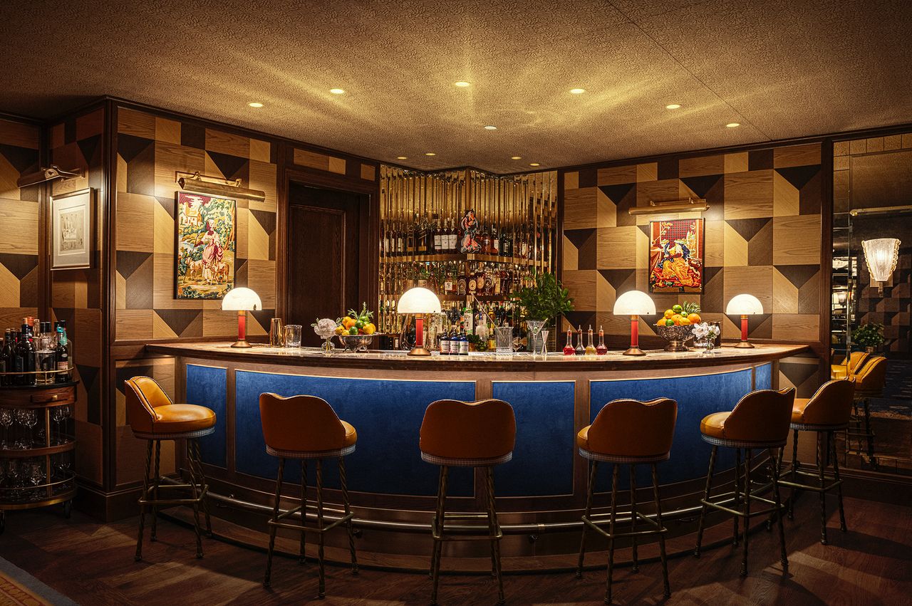 Upscale bar interior with a curved counter barstools and decorative artwork on the walls
