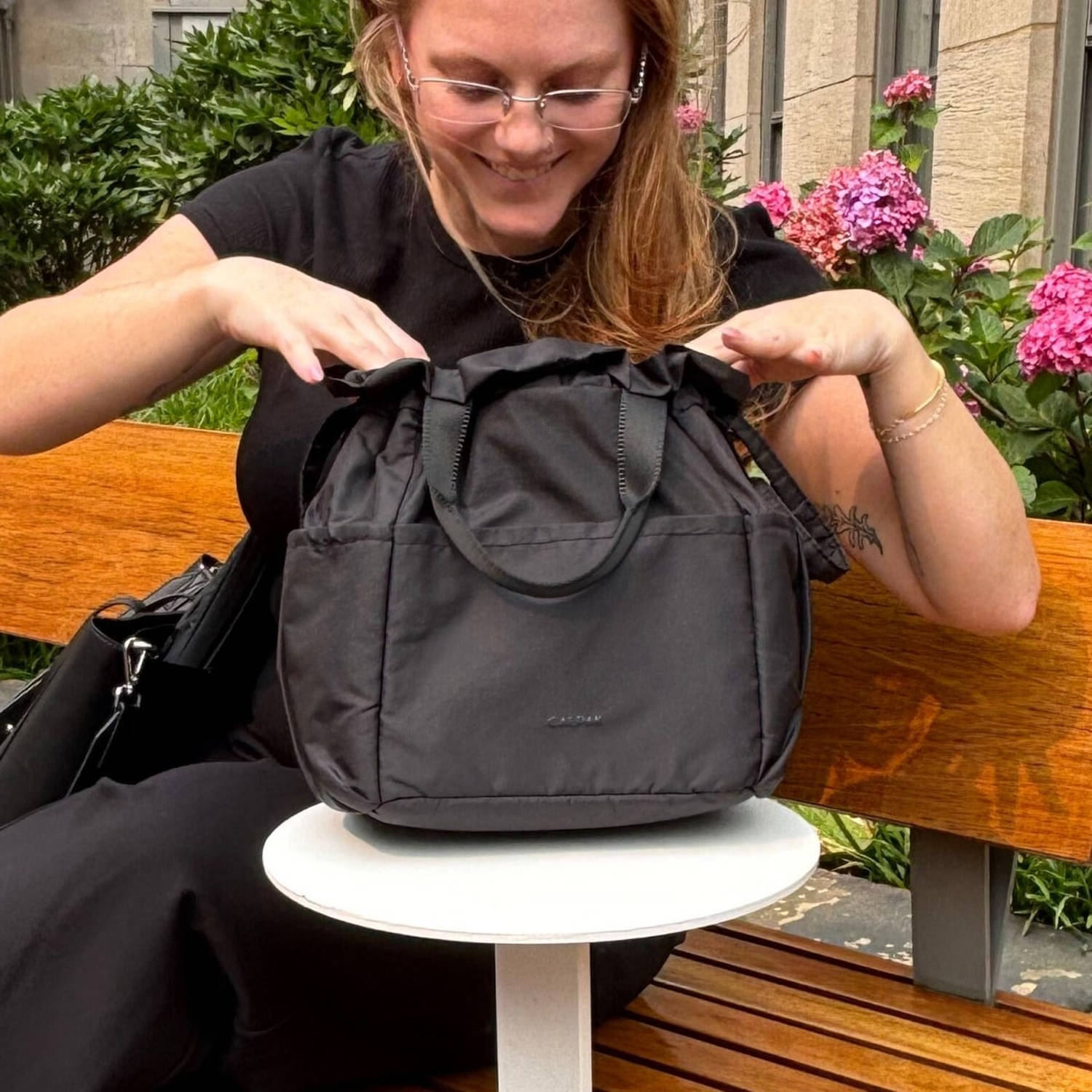 Woman sitting with Calpak Insulated Lunch Bag next to her. (Daaiyah James / NBC News)