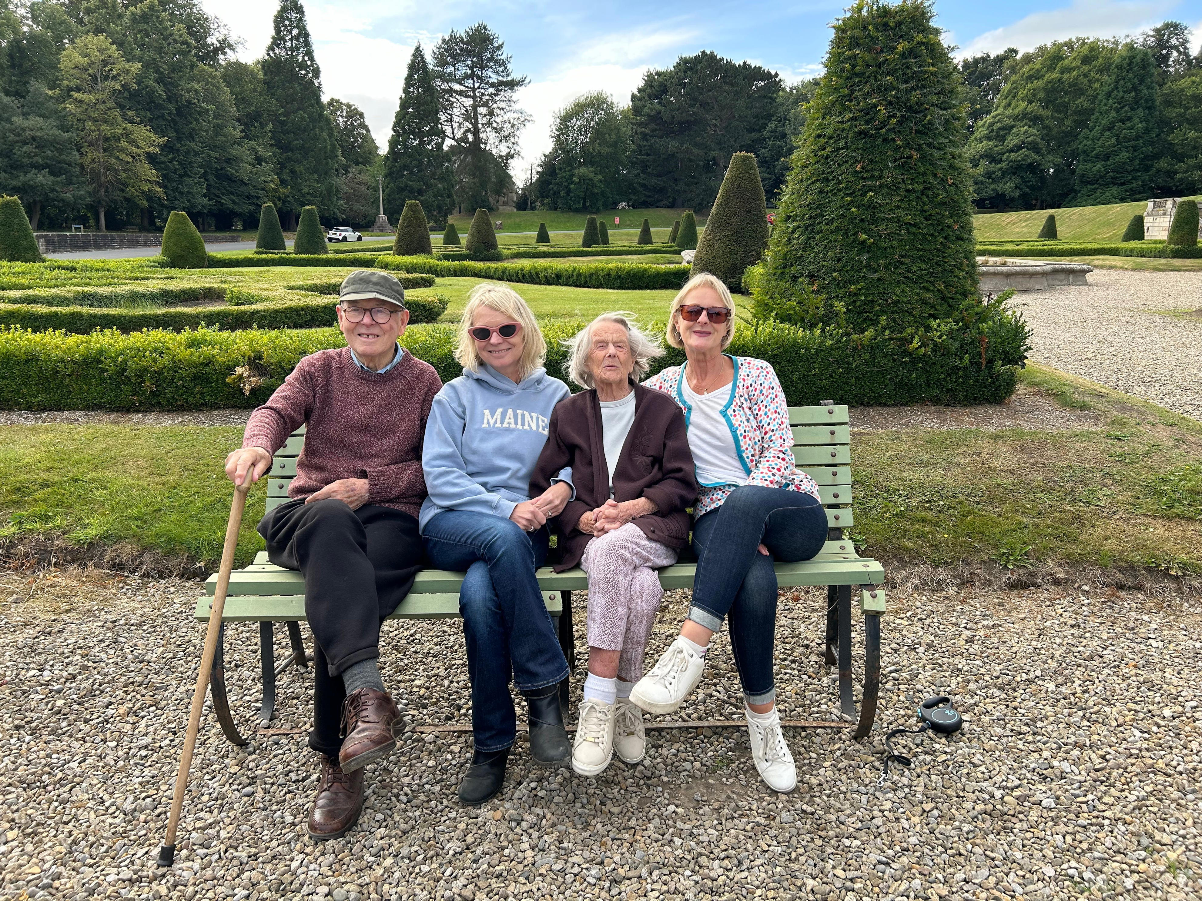 A family of four sitting on a bench