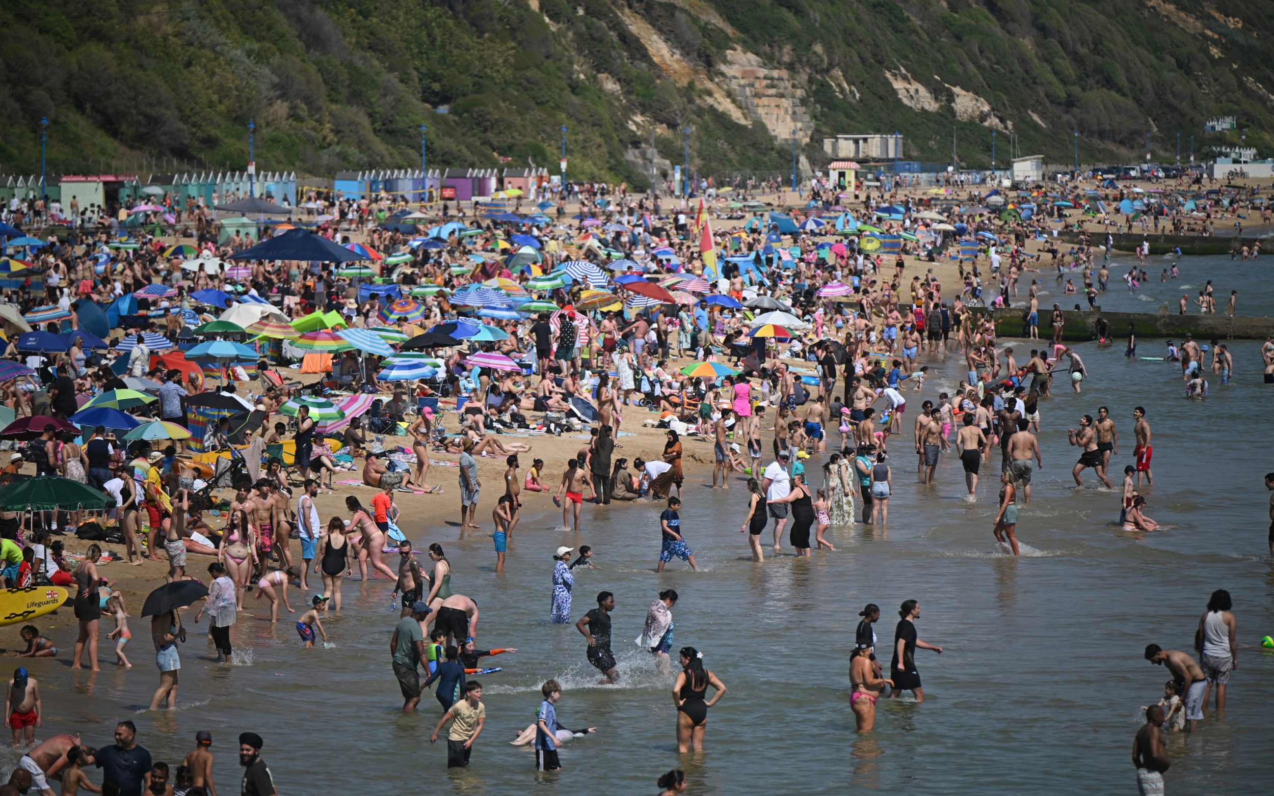 Sunbathers play in the sea and relax in the sunshine on Bournemouth beach on the south coast of England on May 26, 2026