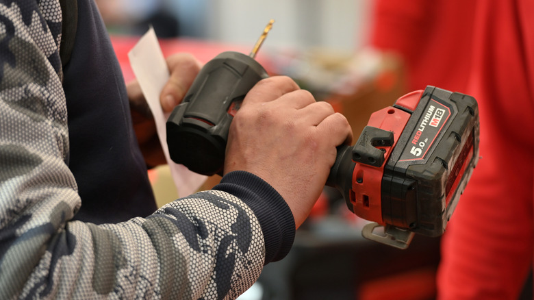 Person evaluating a battery-powered impact driver