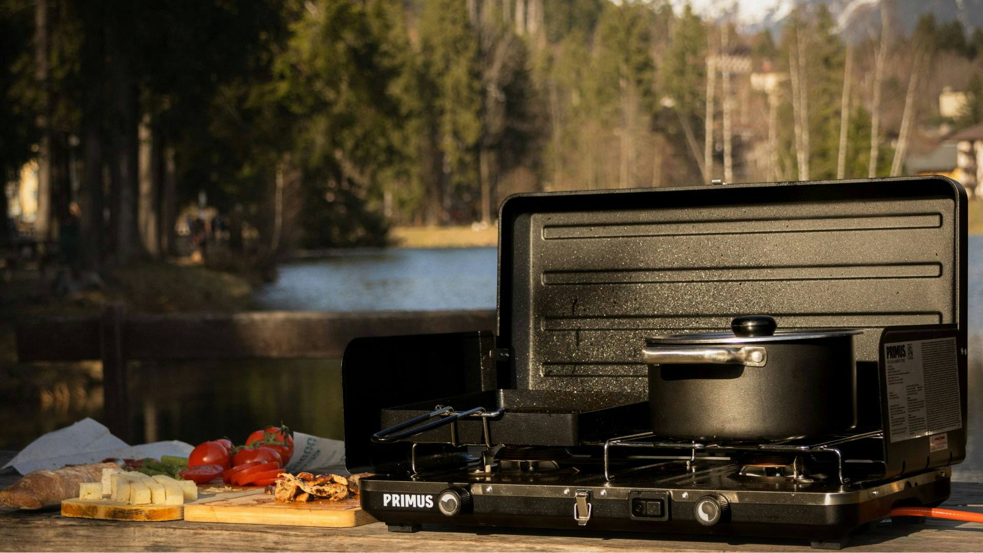 Someone using the Primus Moto Stove to cook in the wilderness