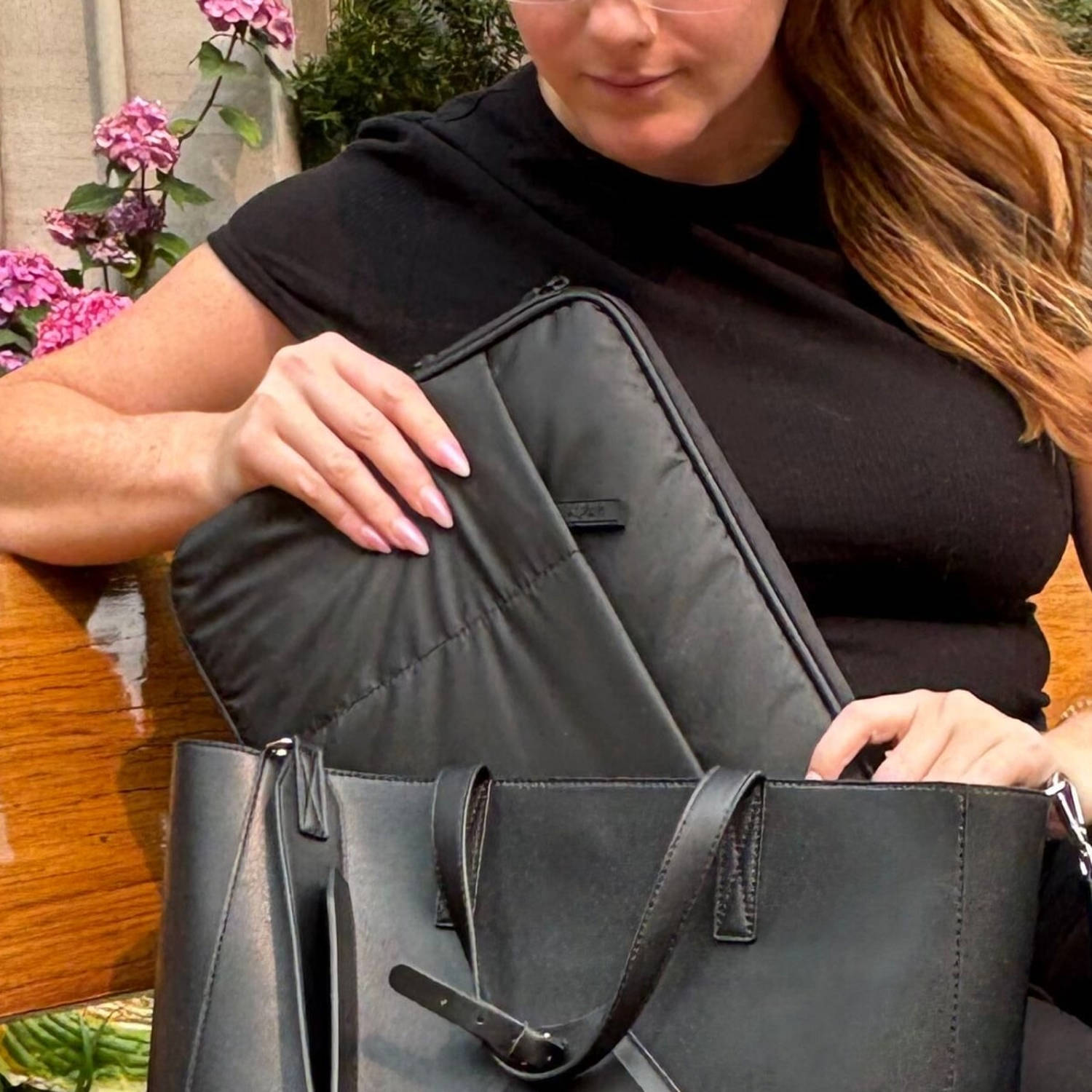 Woman sitting with Luka Padded Laptop Sleeve sitting next to her in the Luka Haven Tote. (Daaiyah James / NBC News)